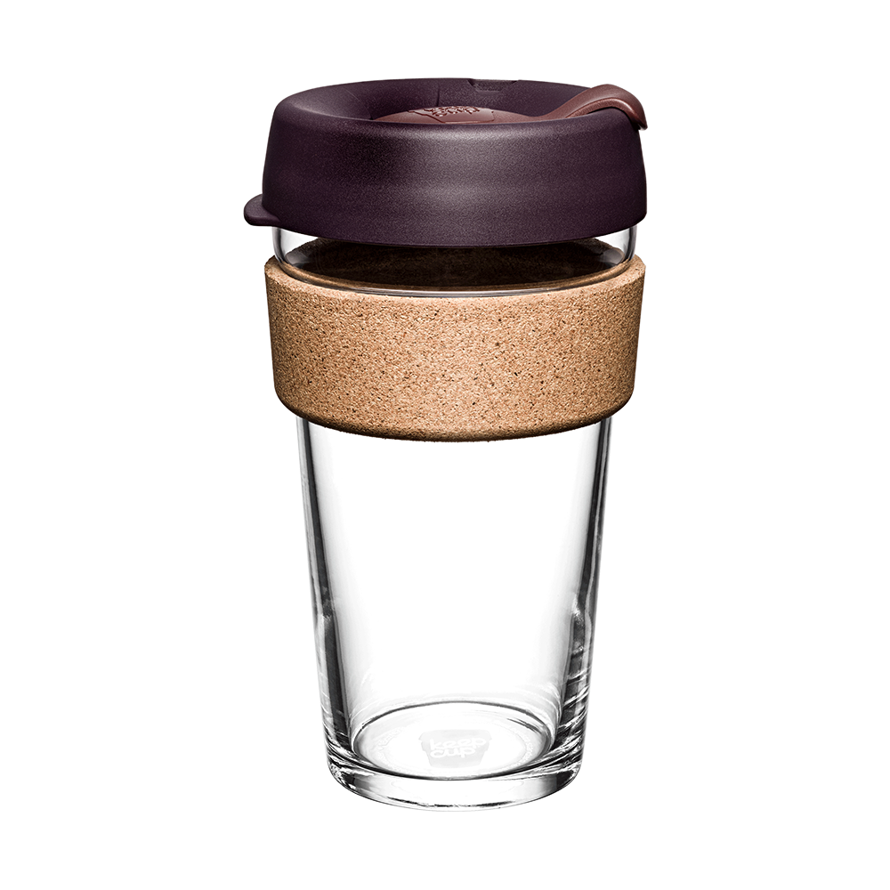 Clear glass reusable coffee cup with a dark brown lid and cork sleeve on a white background