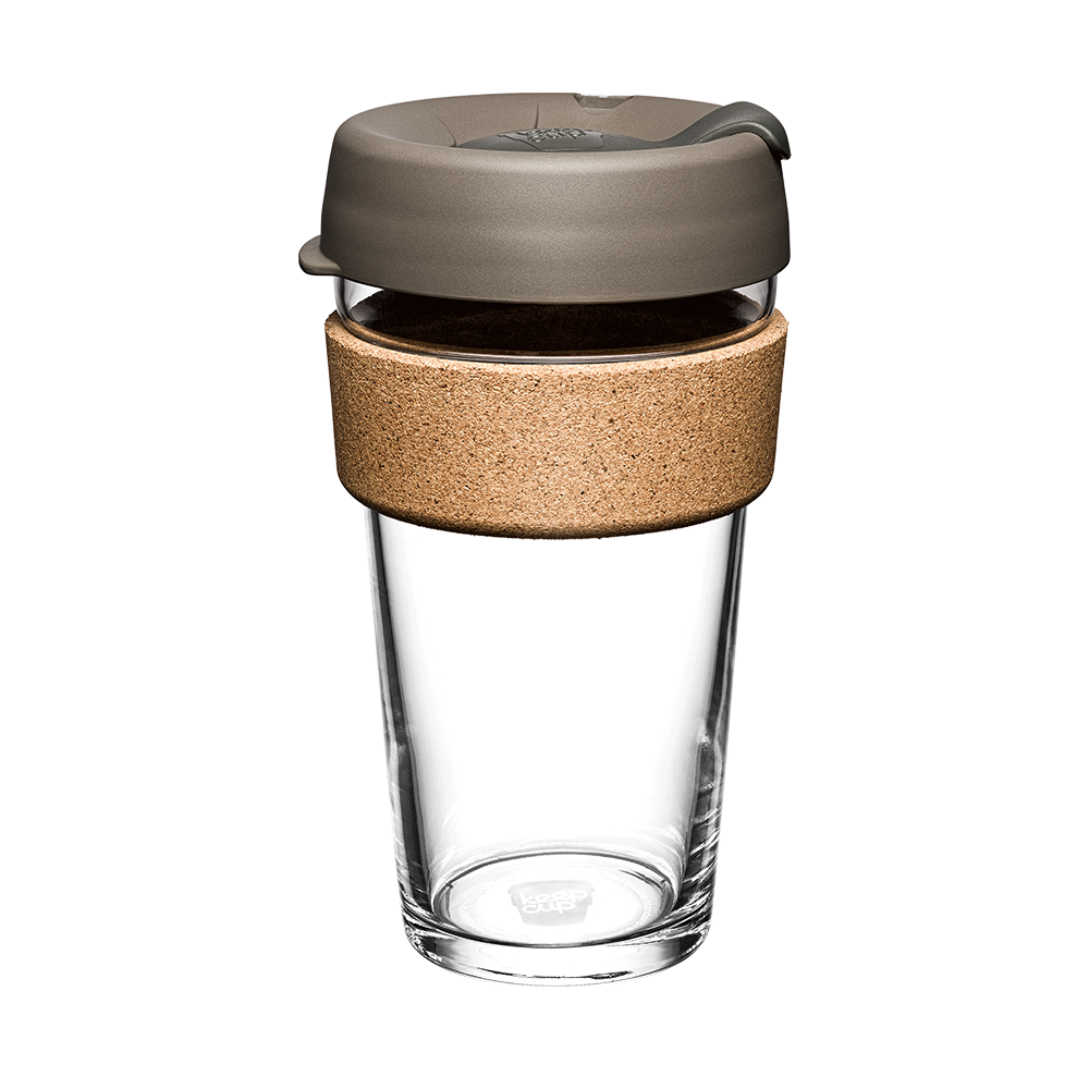 Large clear glass coffee mug with cork sleeve and silver brown lid on a white background