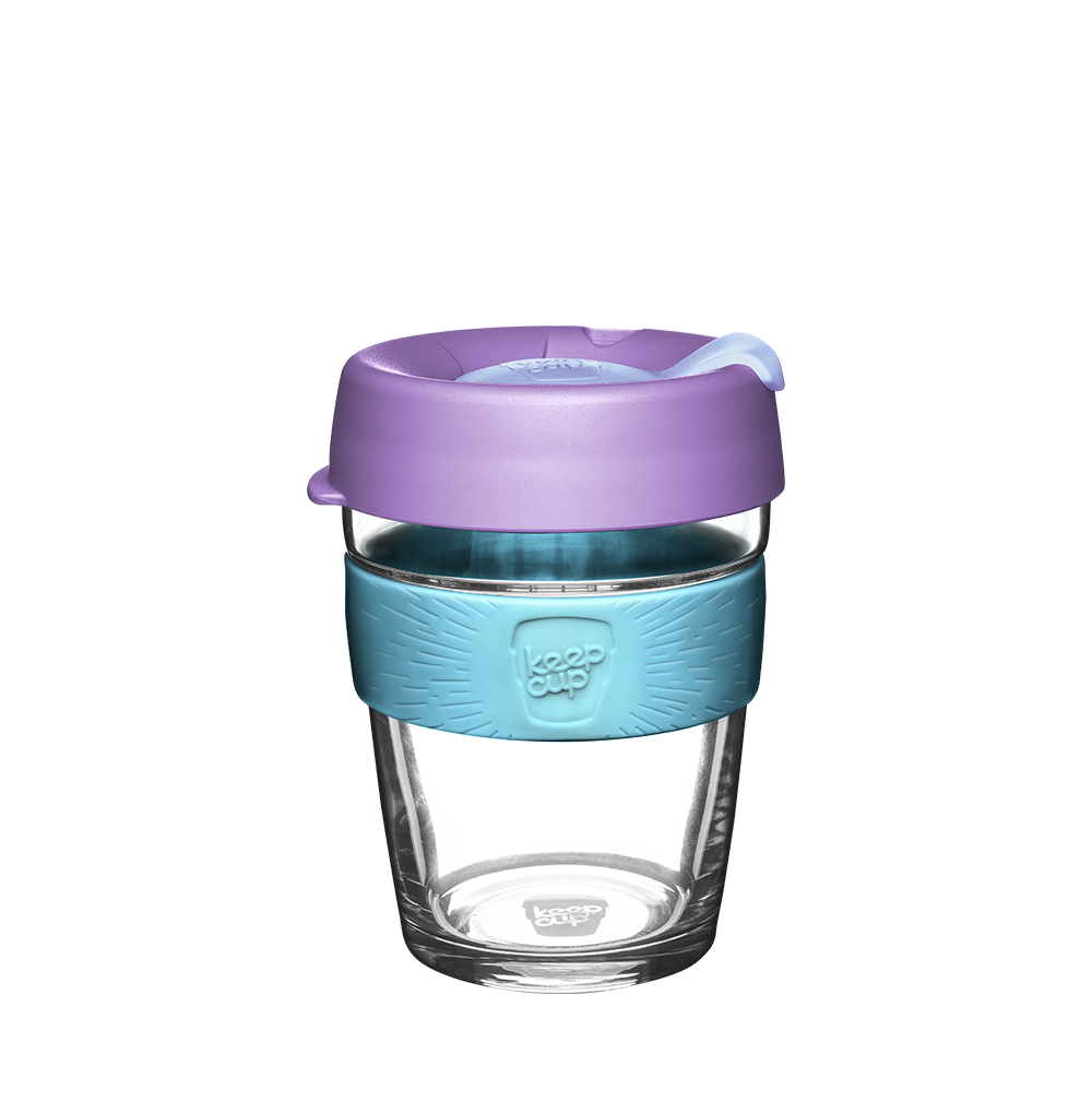 Glass reusable cup with a purple lid and blue sleeve on a white background