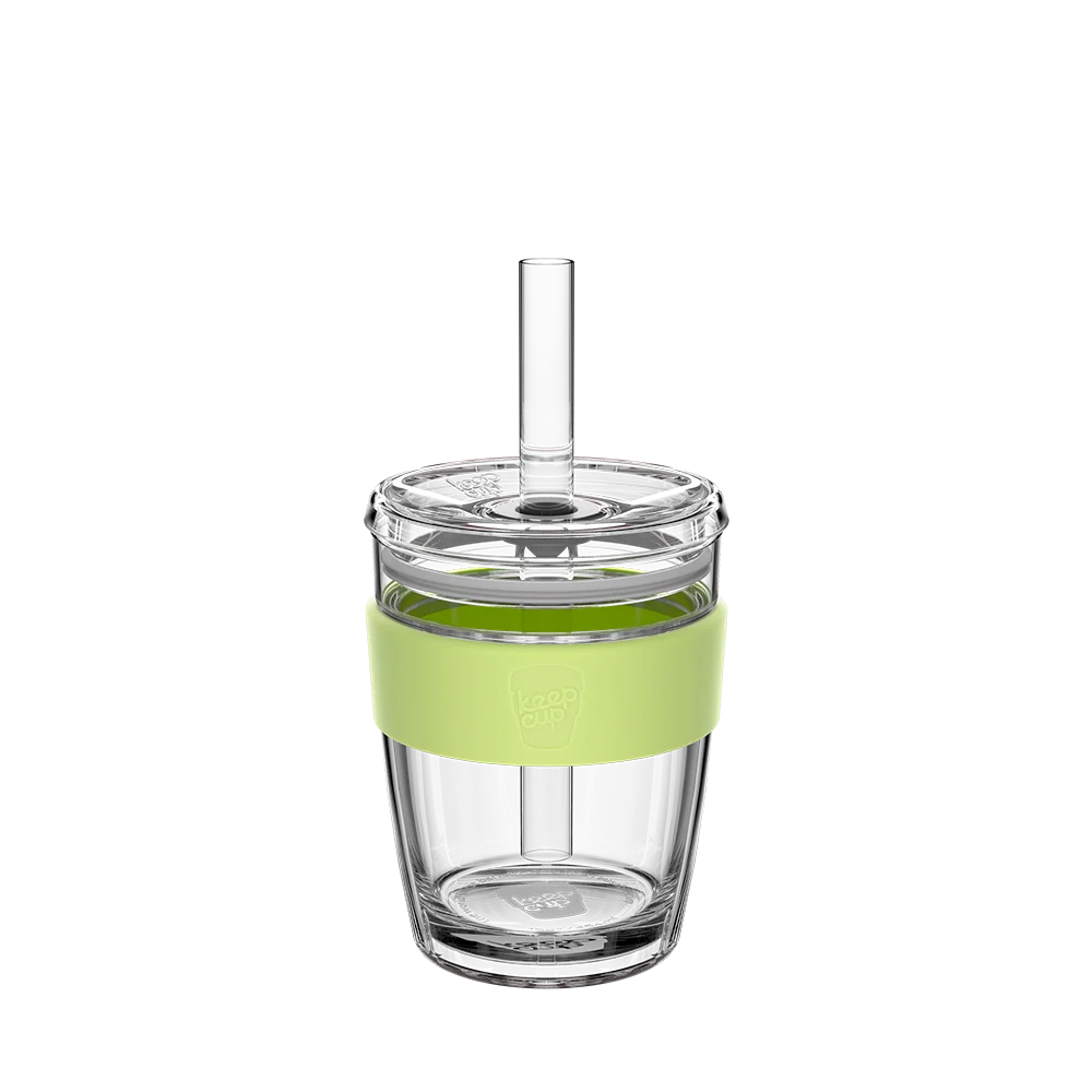 Glass straw tumbler with a green band and straw on a white background