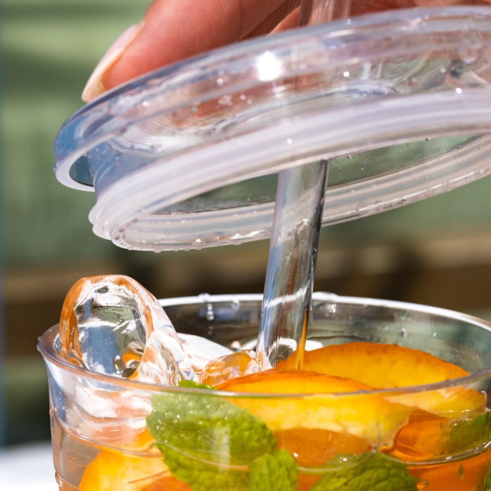 Clear plastic cup with fruit and ice, showing press fit Keepcup straw lid close up