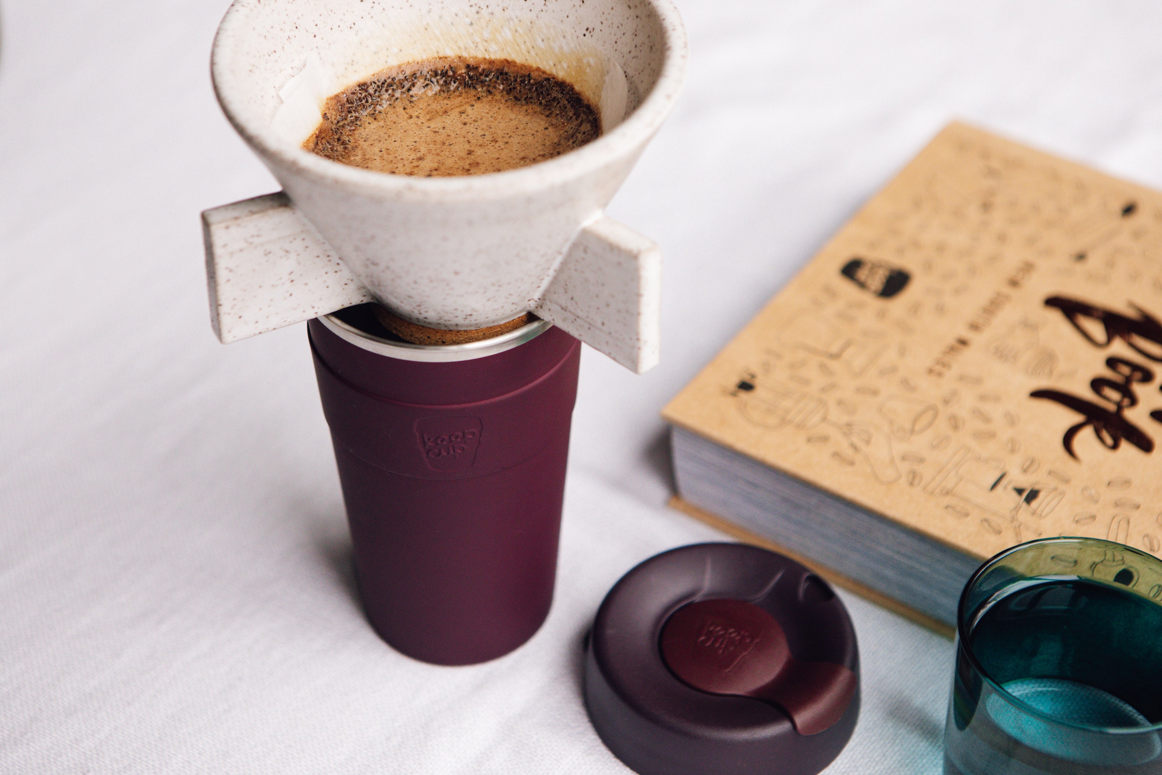 Coffee brewing device with a cup of coffee on a white surface