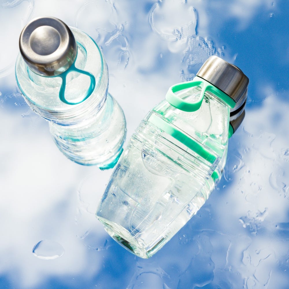 Two water bottles with green accents on a blue water background