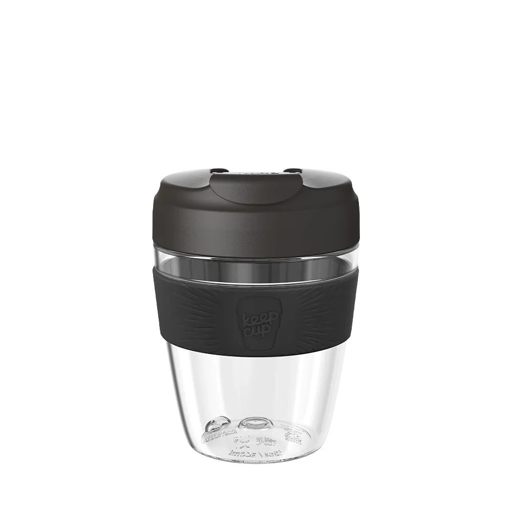 Clear reusable coffee cup with black lid and sleeve on a white background