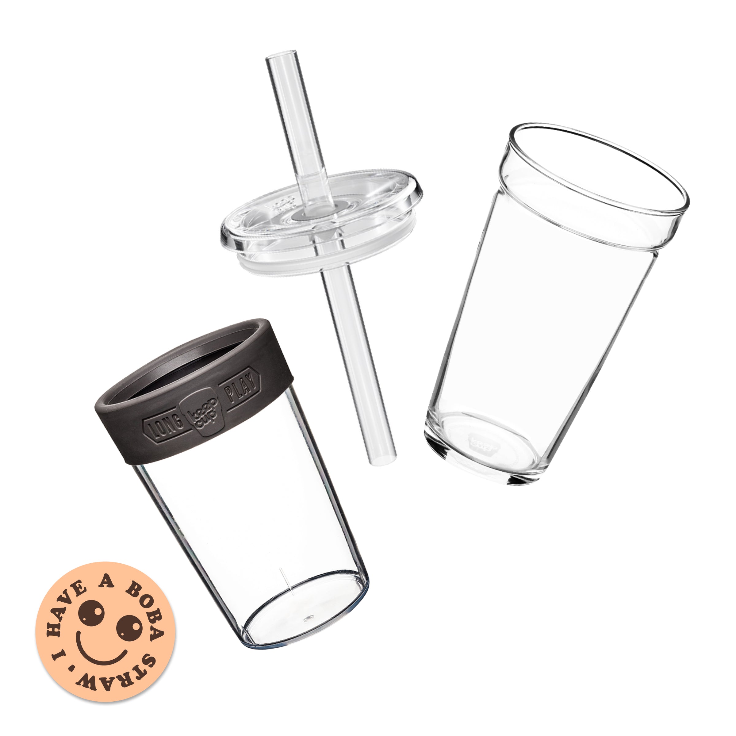 Exploded view of the KeepCup Cold Cup Longplay Boba L 16oz showing three components: a clear glass cup, a clear lid with wide boba straw, and a Soft Charcoalband, alongside a peach-coloured sticker reading "I have a boba straw" with a smiley face.