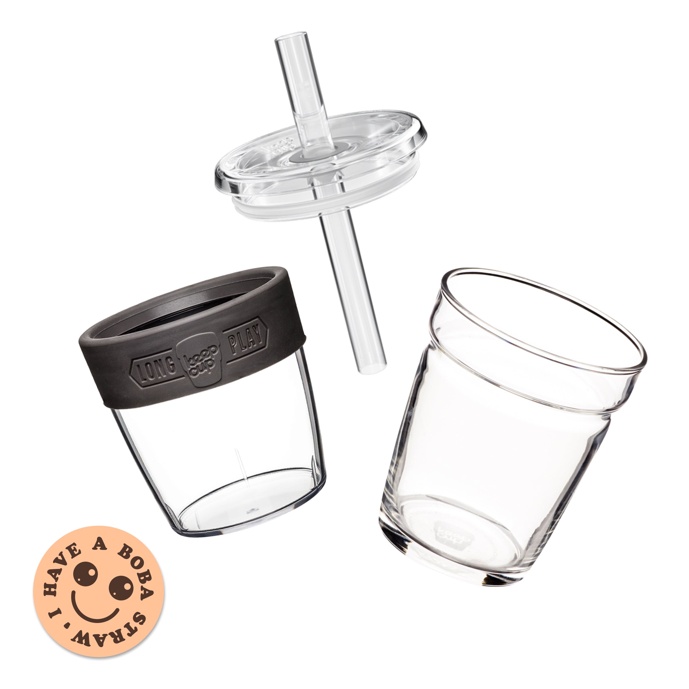 Exploded view of the Cold Cup Longplay Boba M 12oz showing the clear glass cup, band with "Longplay KeepCup" embossing, transparent lid with wide boba straw, and a peach-coloured "I Have A Boba Straw" sticker featuring a smiley face.