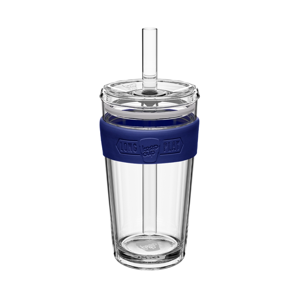 Clear tumbler with a blue sleeve and straw on a white background