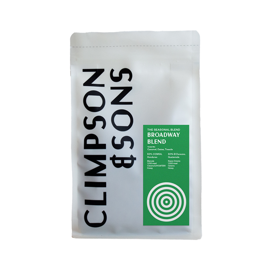 White coffee bag of Climpson & Sons Broadway Blend 250g, featuring bold black vertical text on the left and a green label detailing the seasonal blend with tasting notes of caramel, dates and treacle, made from 50% Honduras and 50% Guatemala beans.