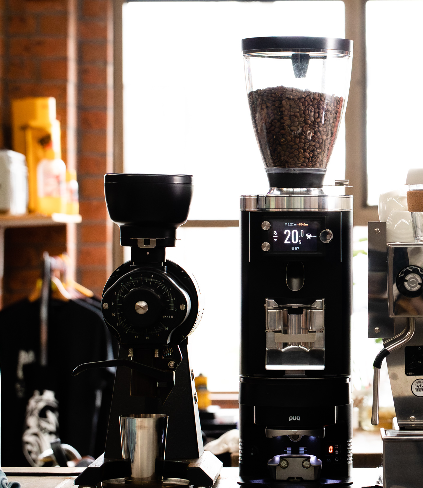 Two coffee grinders side by side with a blurred background