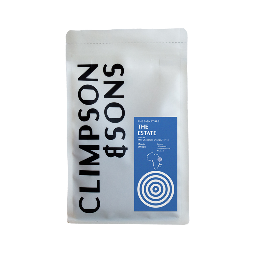 White coffee bag from Climpson & Sons featuring "The Estate" signature blend, with a blue label showing tasting notes of milk chocolate, orange and toffee, sourced from Sidamo, Ethiopia, displayed against a plain background.