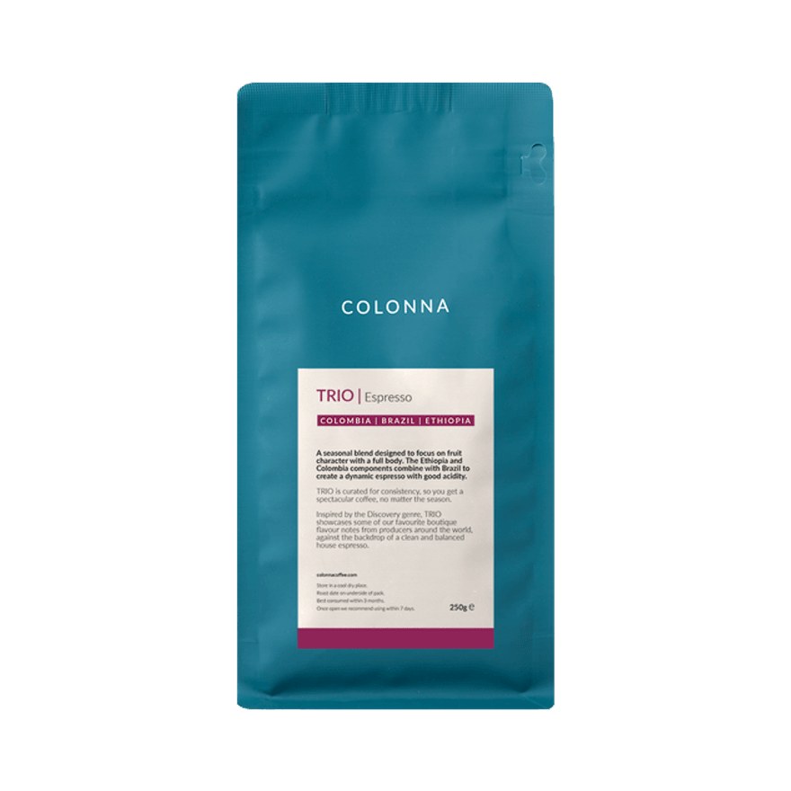 A 250g teal bag of Colonna TRIO Espresso coffee blend, featuring a cream-coloured label indicating origins from Colombia, Brazil and Ethiopia, photographed against a light grey background.
