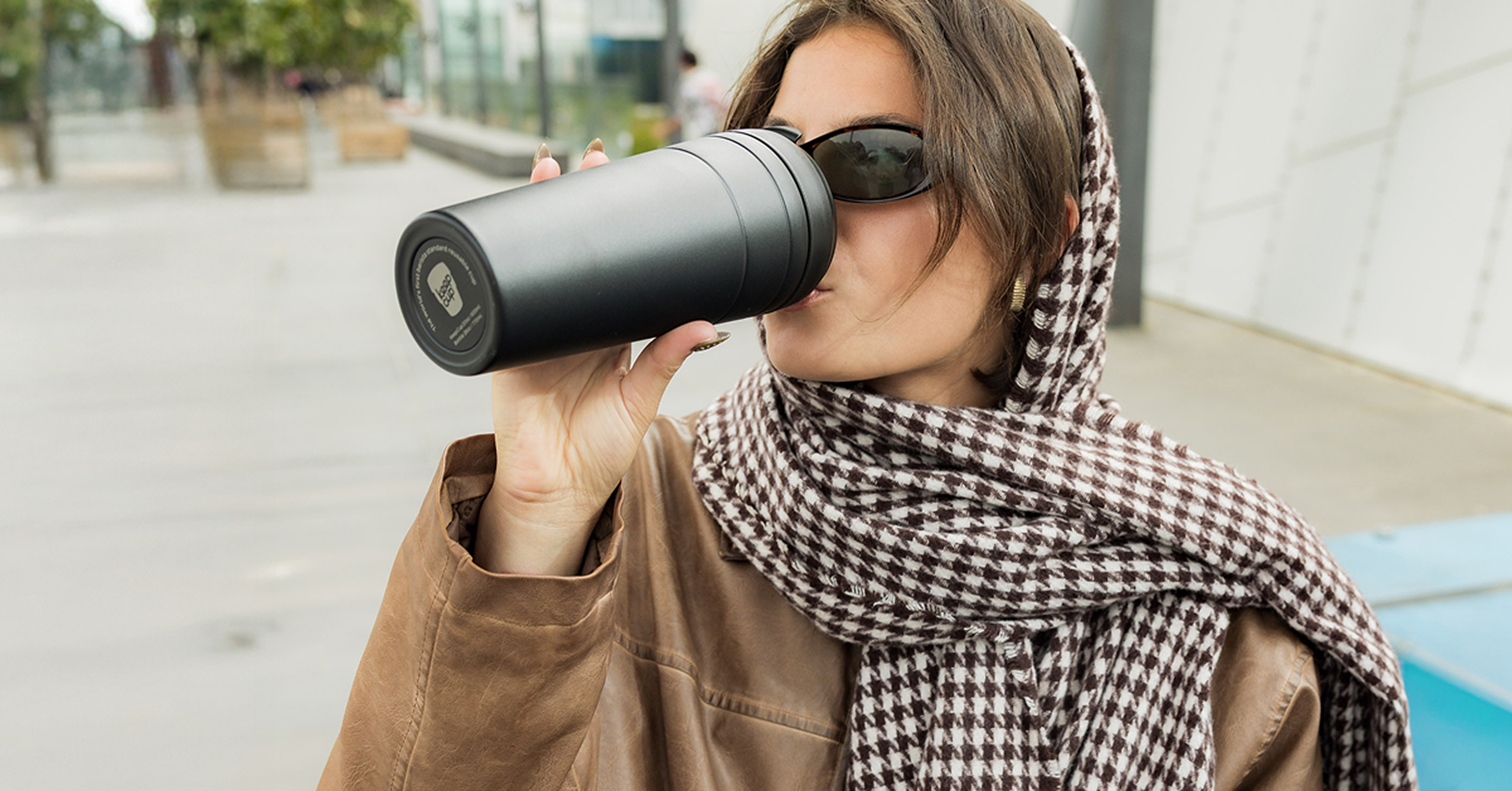Woman drinking from a insulated tumbler outdoors