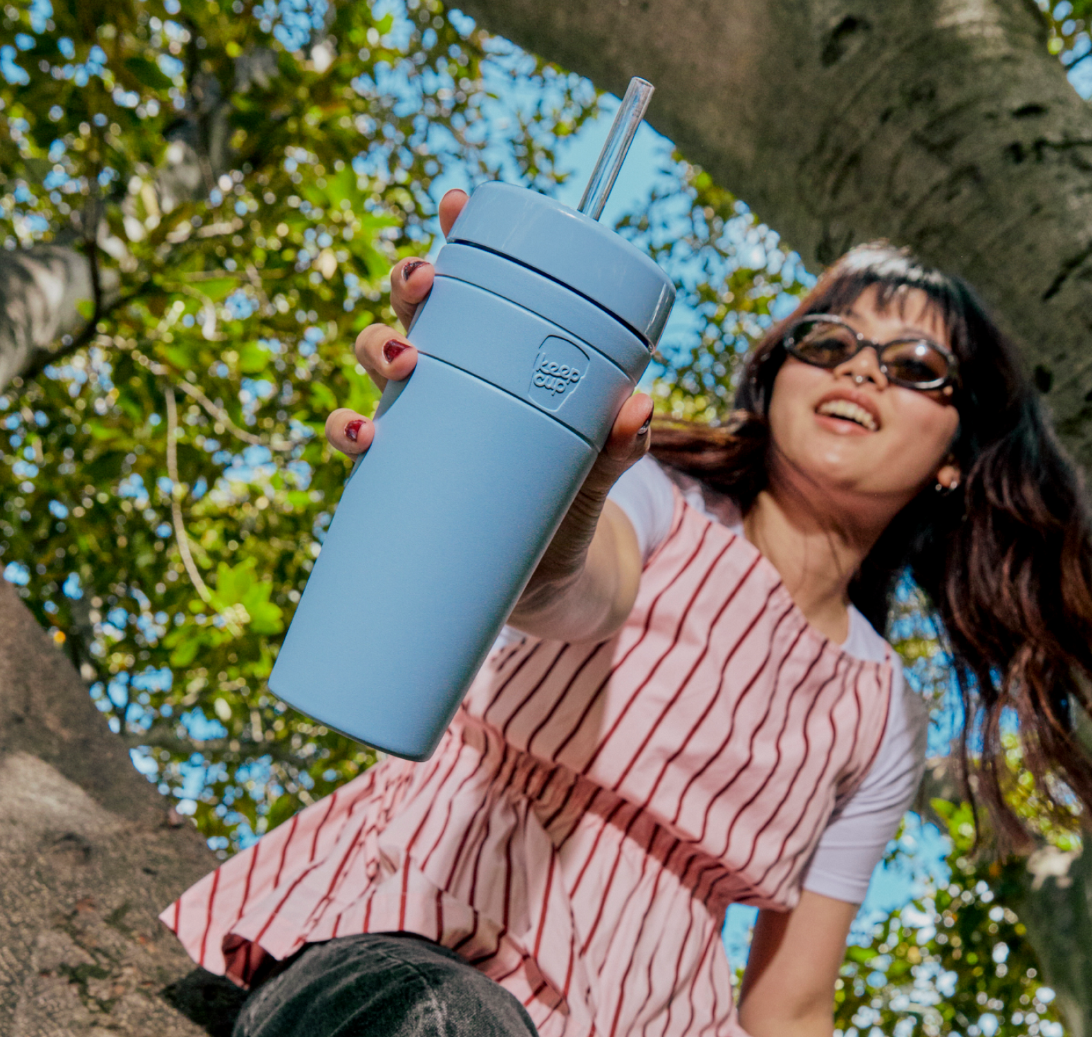 Person holding a Commuter Cold Cup in Orchid outdoors with trees in the background
