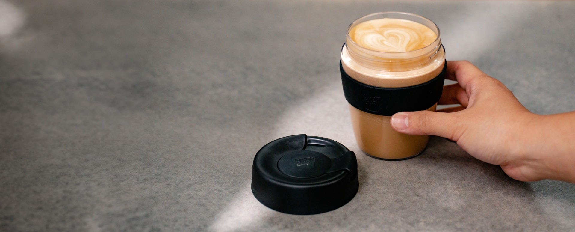 Woman holding KeepCup Traveller Light 12oz with coffee