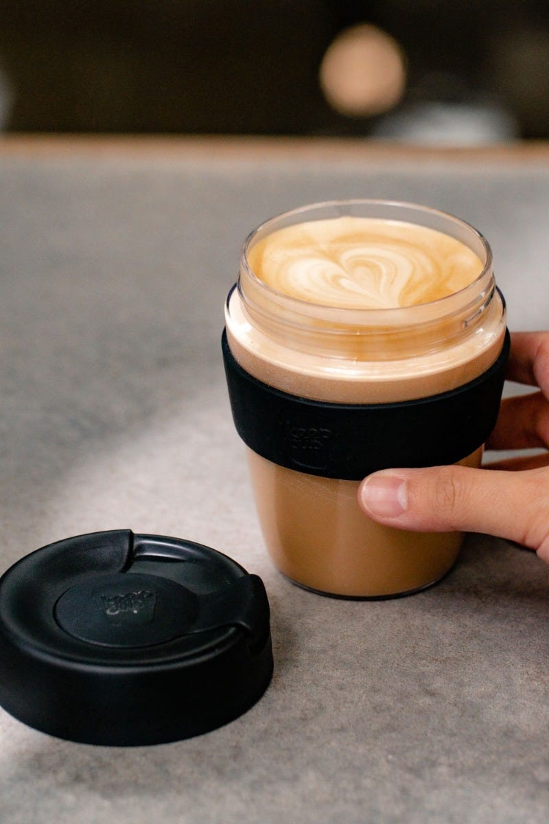 Woman holding KeepCup Traveller Light 12oz with coffee