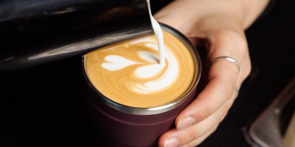 Barista pouring milk into KeepCup Thermal